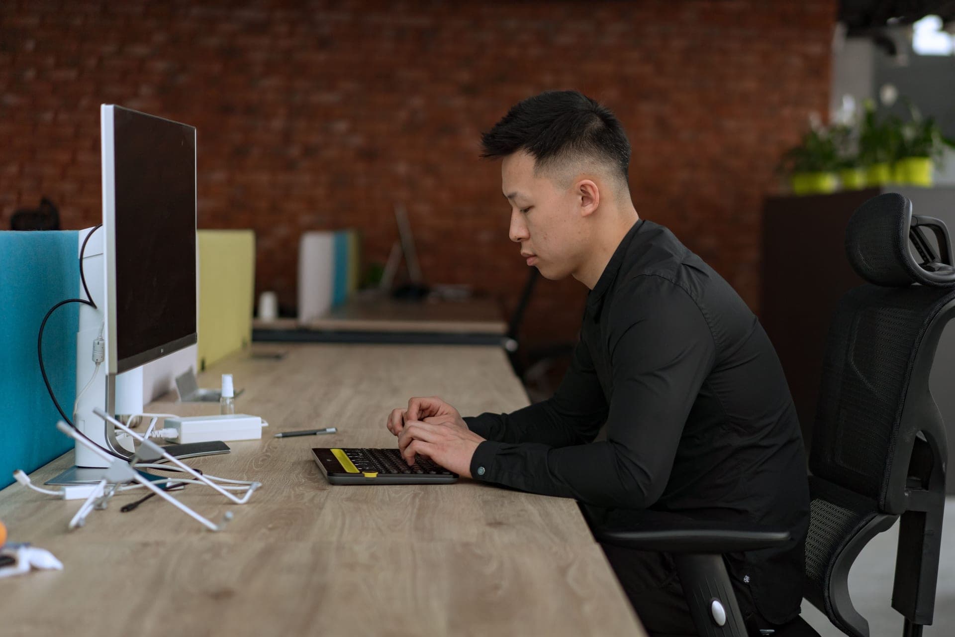 A person seated at a desk with forearms level and feet flat