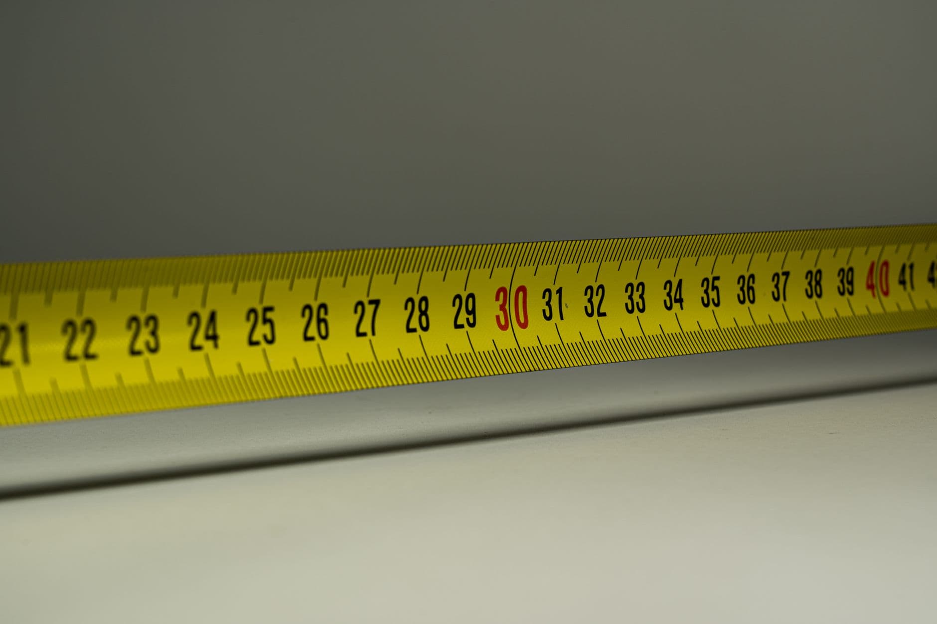 A close view of a yellow measuring tape marked in centimeters