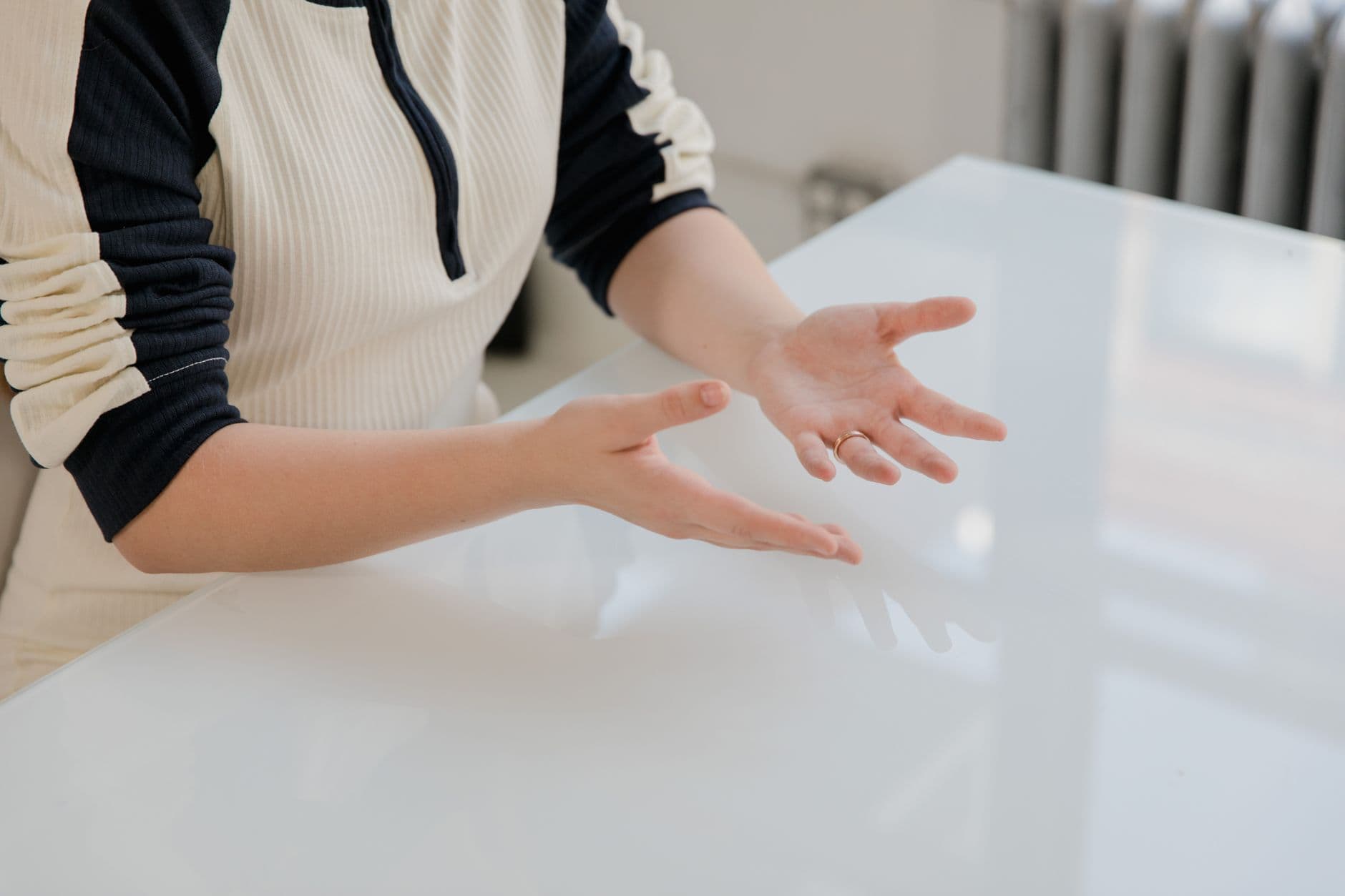 Forearms resting on the edge of a white desk
