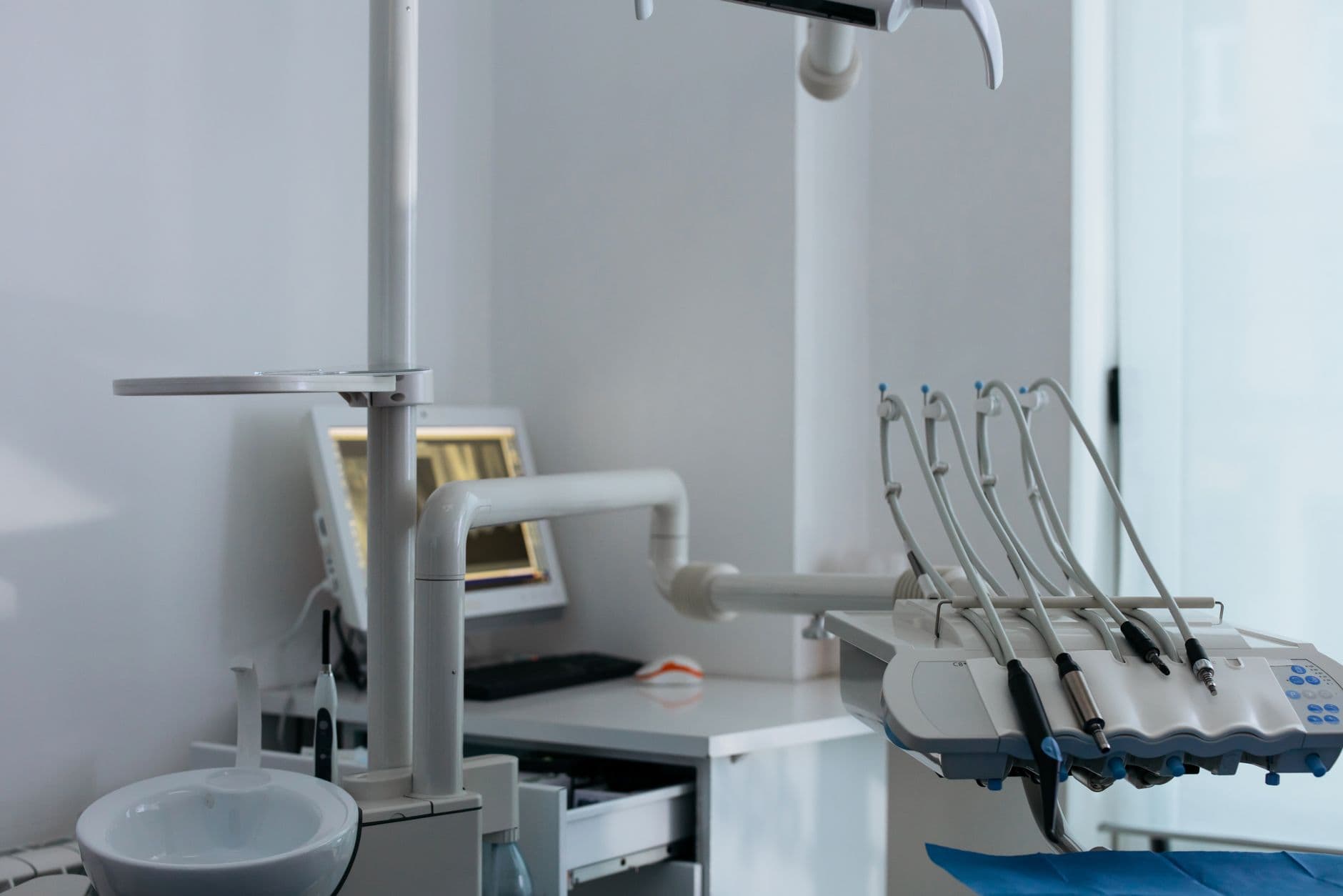 A dental chair and instrument tray in a bright clinic