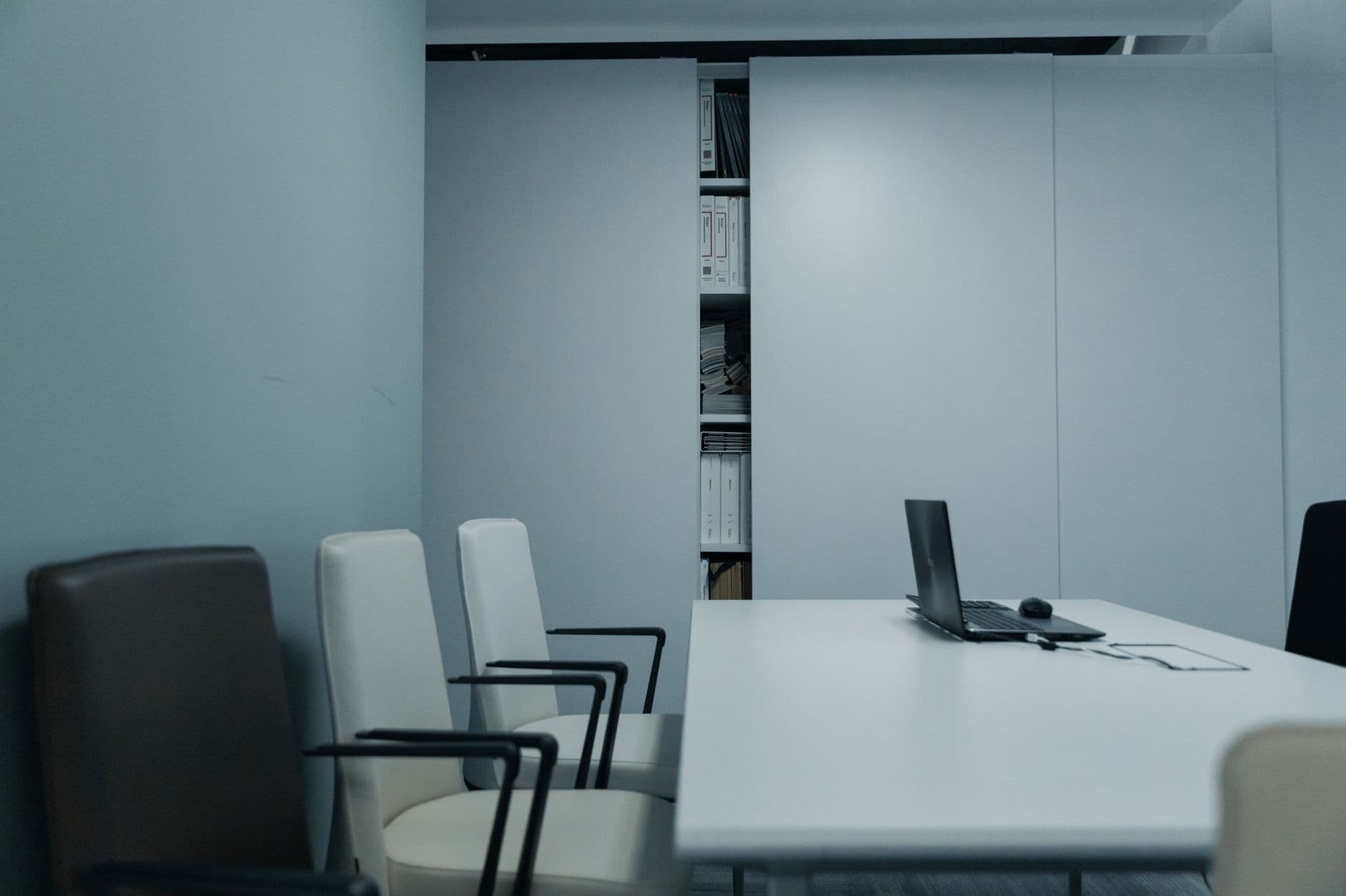 A meeting room with mesh-backed chairs around a white table