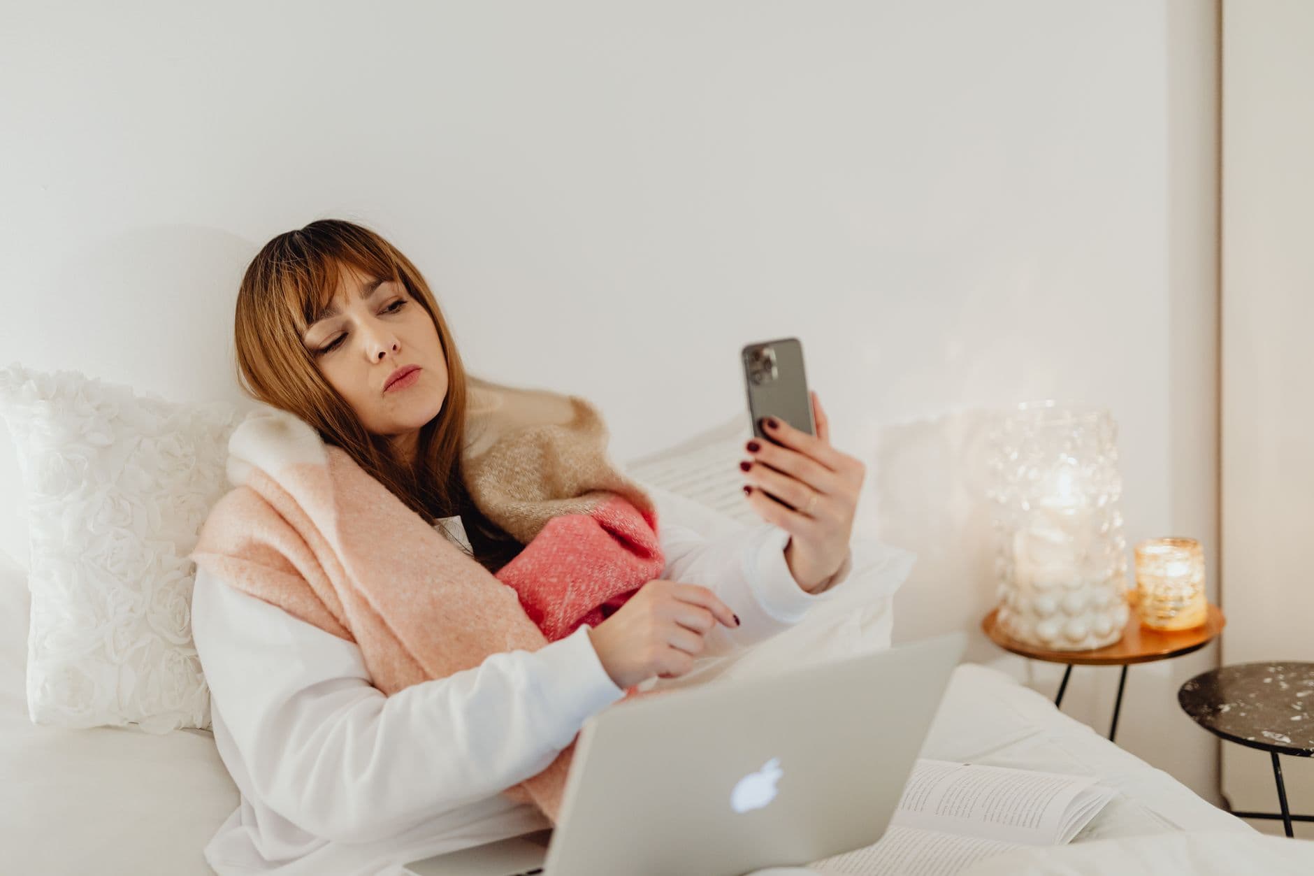 A person in a scarf working on a laptop in a cold room