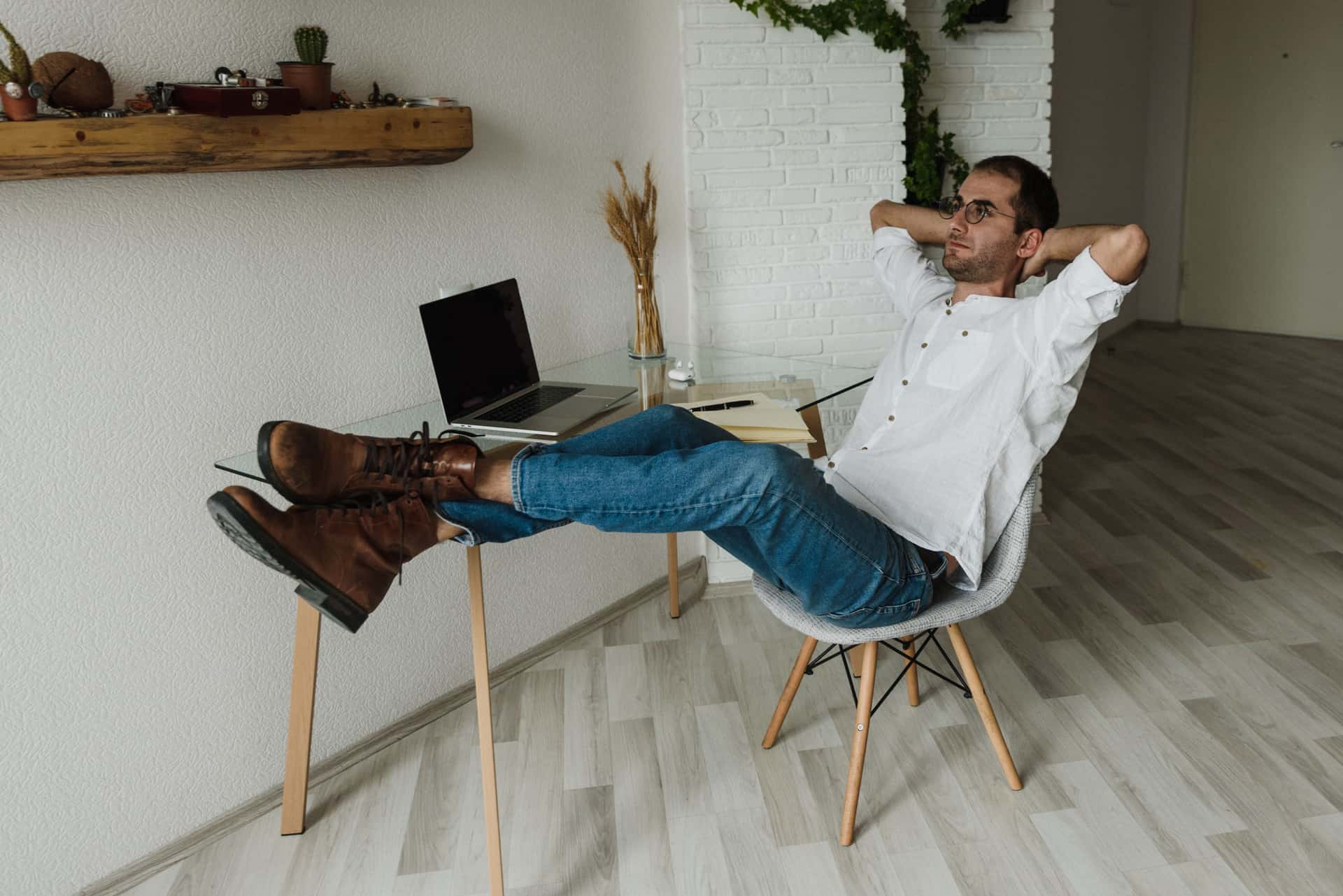 An adjustable kneeling chair with a wooden frame beside a desk