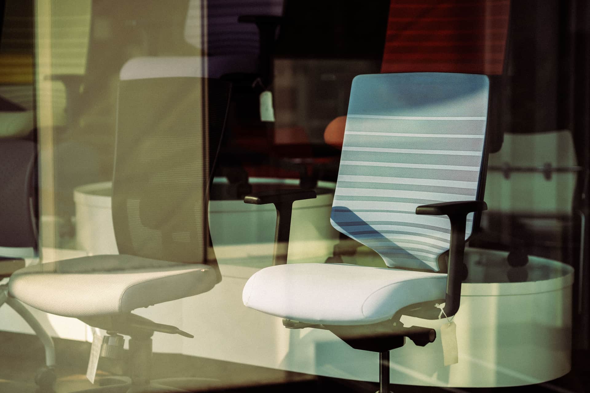 A memory-foam lumbar support cushion strapped to the back of an office chair