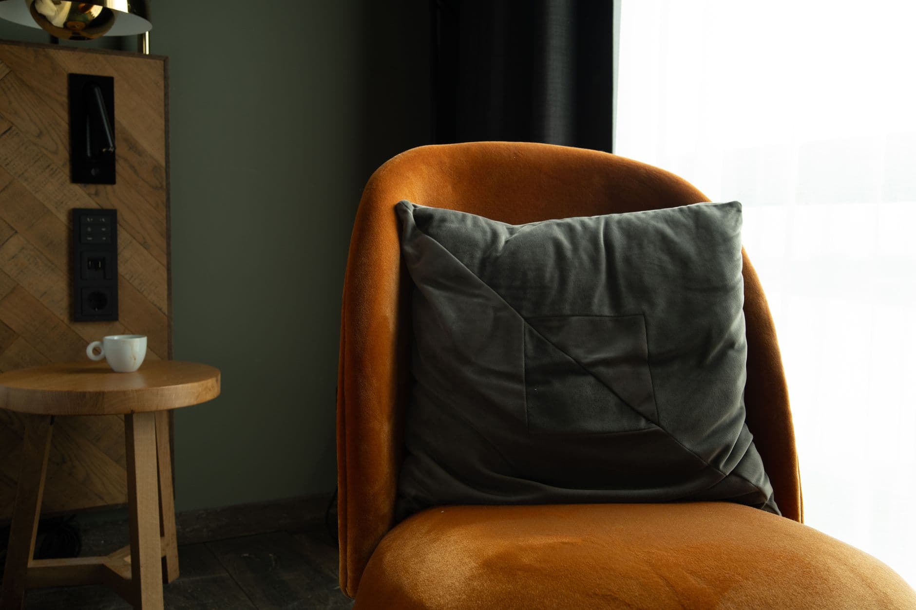 A gray cushion on an upholstered chair in a quiet corner