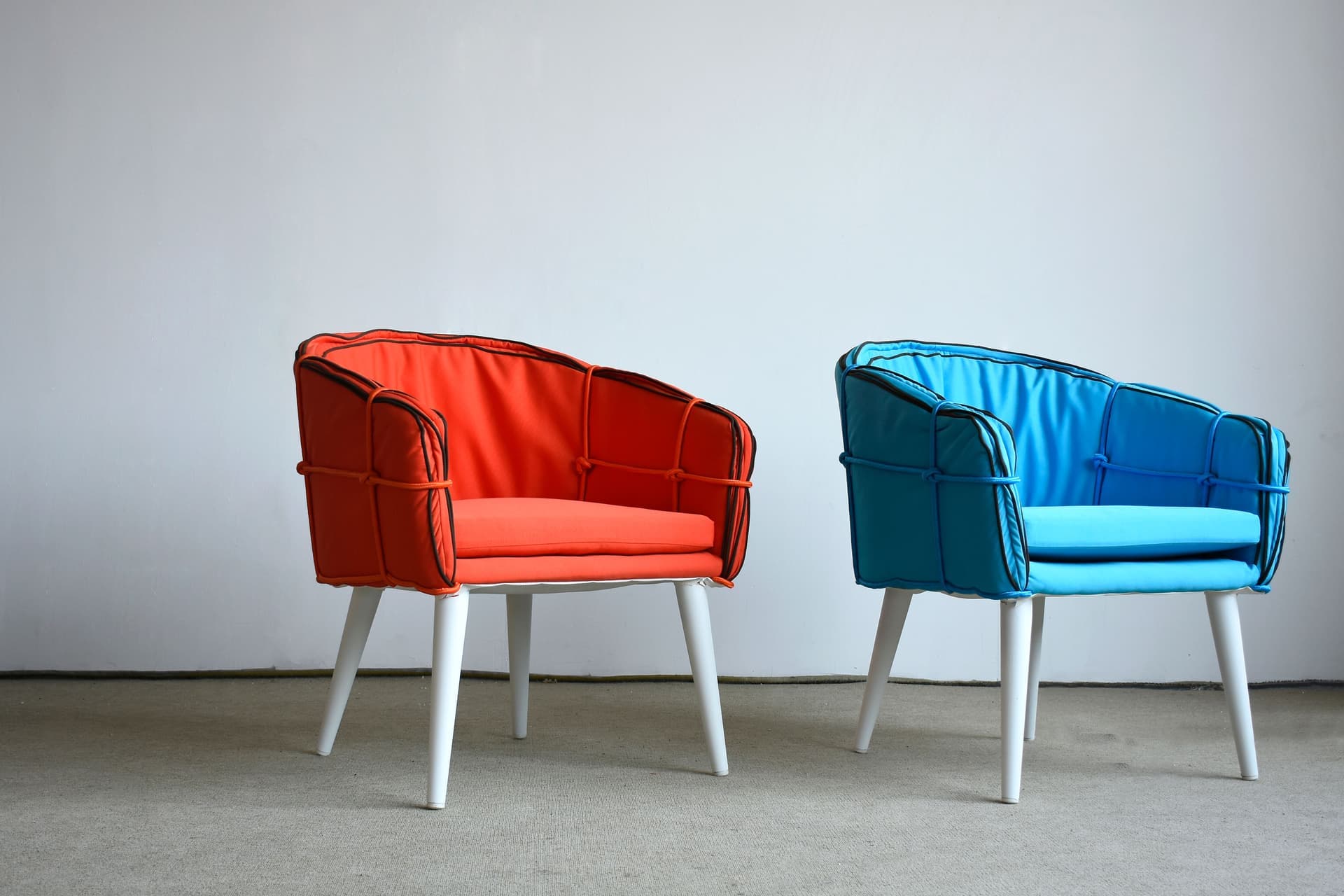 A mesh-backed office chair beside a padded upholstered office chair