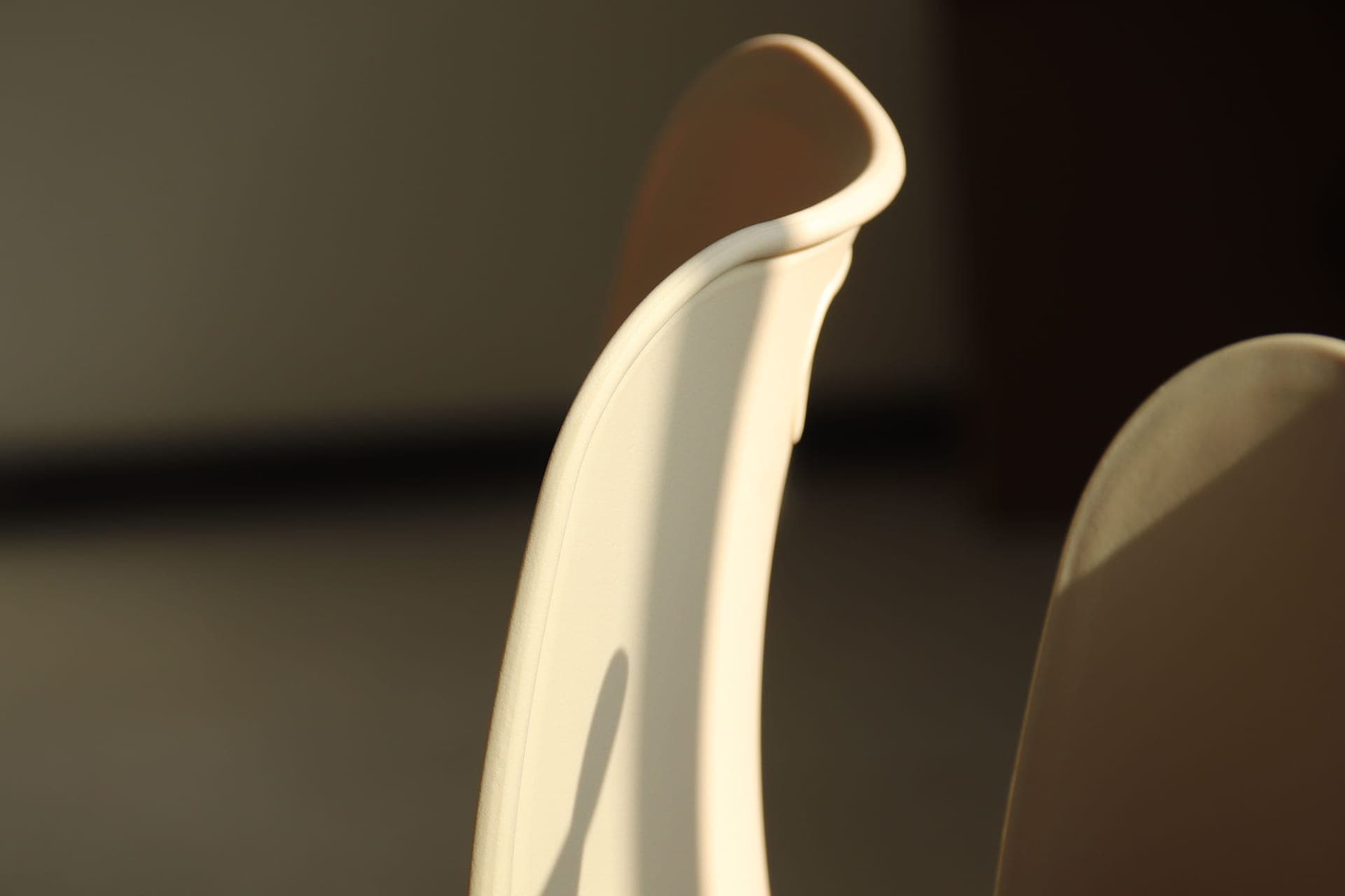 An ergonomic chair reclined back with a waterfall-edge seat, seen from the side