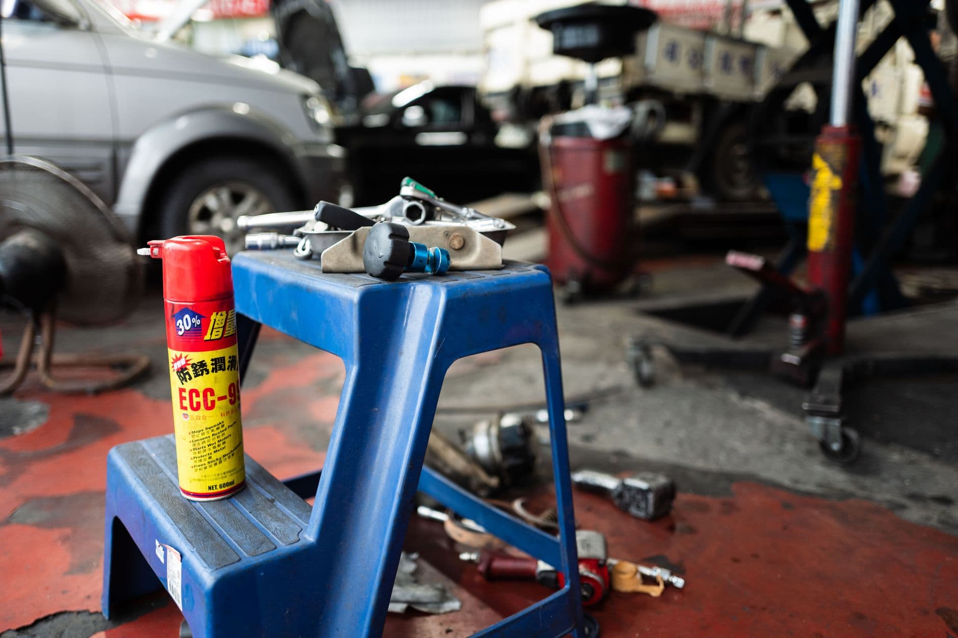 A stool and scattered tools in an automotive workshop