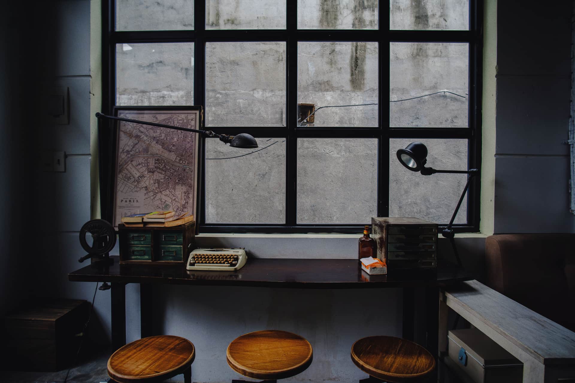 A height-adjustable perching stool at a standing-height desk in daylight