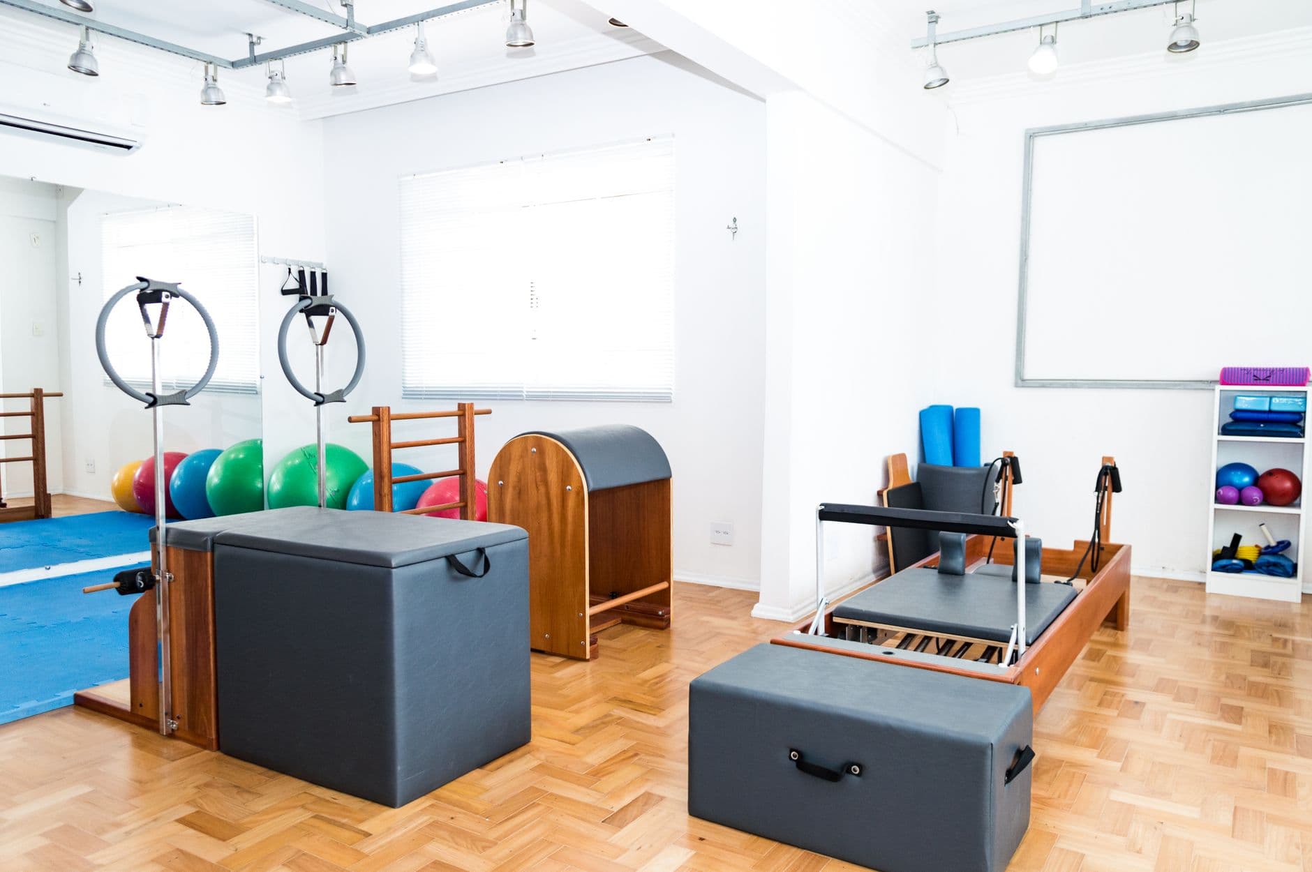 A bright studio with exercise balls and mats on the floor